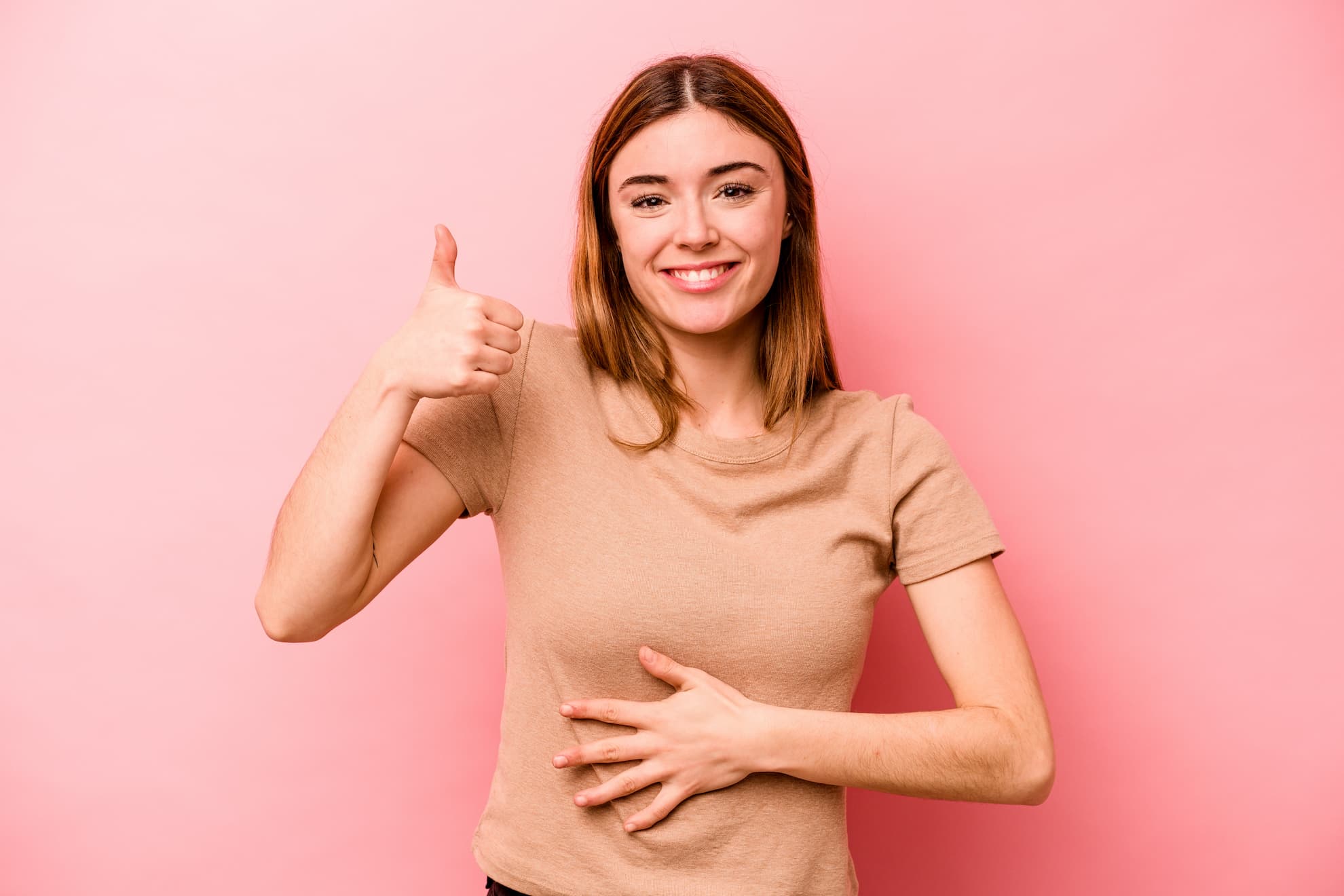 Femme souriante se touchant le ventre, signe d'une bonne digestion